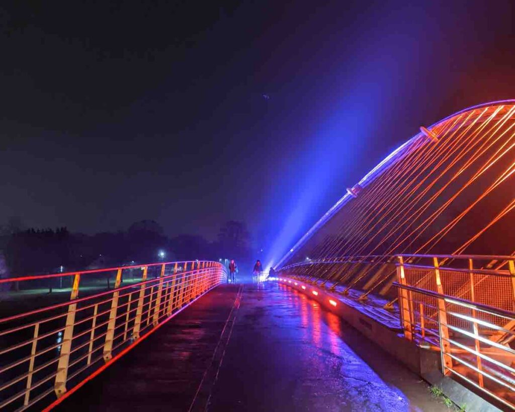 Running along a lit up Millennium Bridge at Night, York