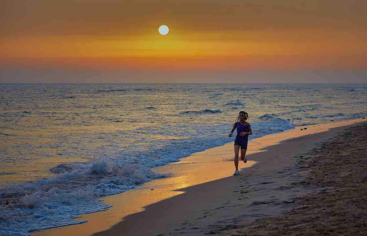 Happy woman running on a beach