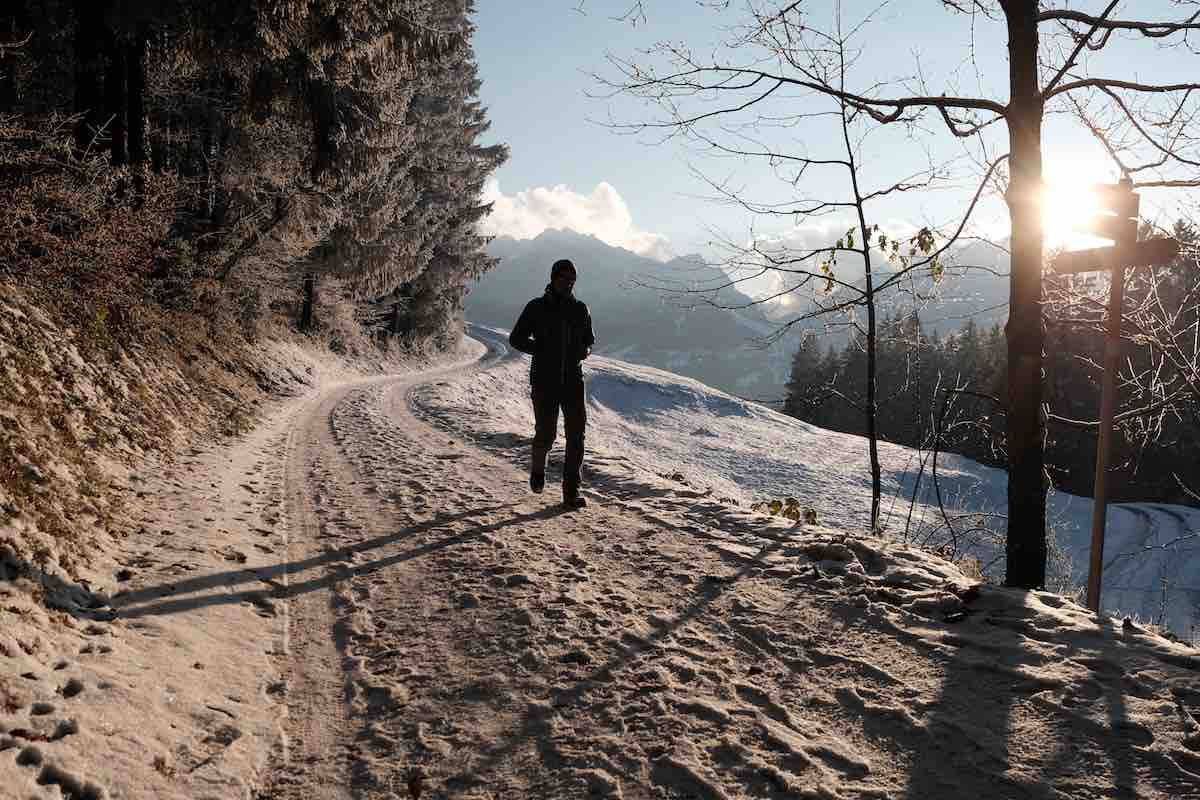 Runner in snow along a mountain road